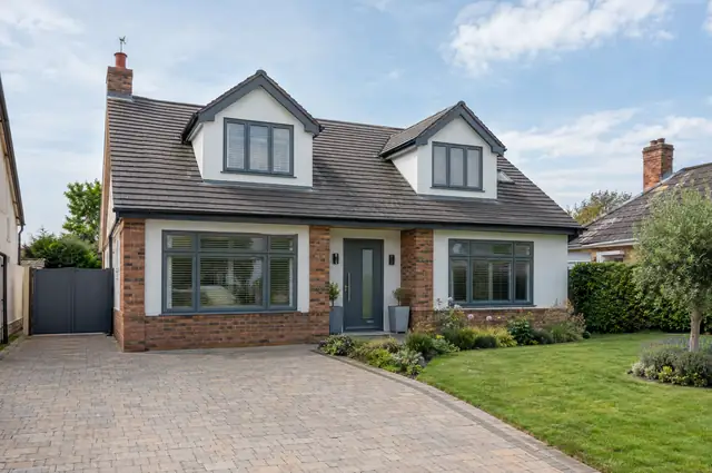 Detached bungalow converted to a chalet-style house with front dormers and a raised roof