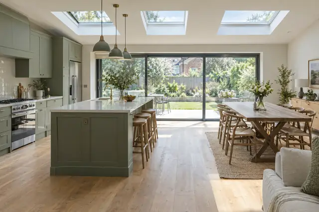Open-plan kitchen extension with sage green units, island and rooflights
